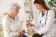 Doctoring checking blood sugar of elderly diabetic woman