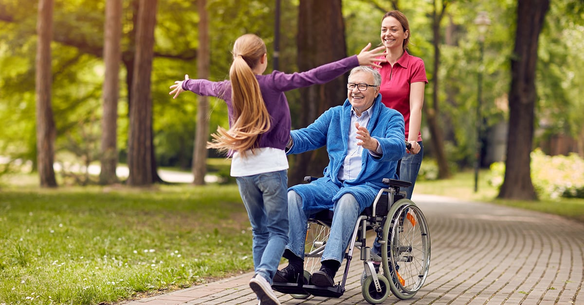 Grandfather in a wheelchair with his daughter and granddaughter