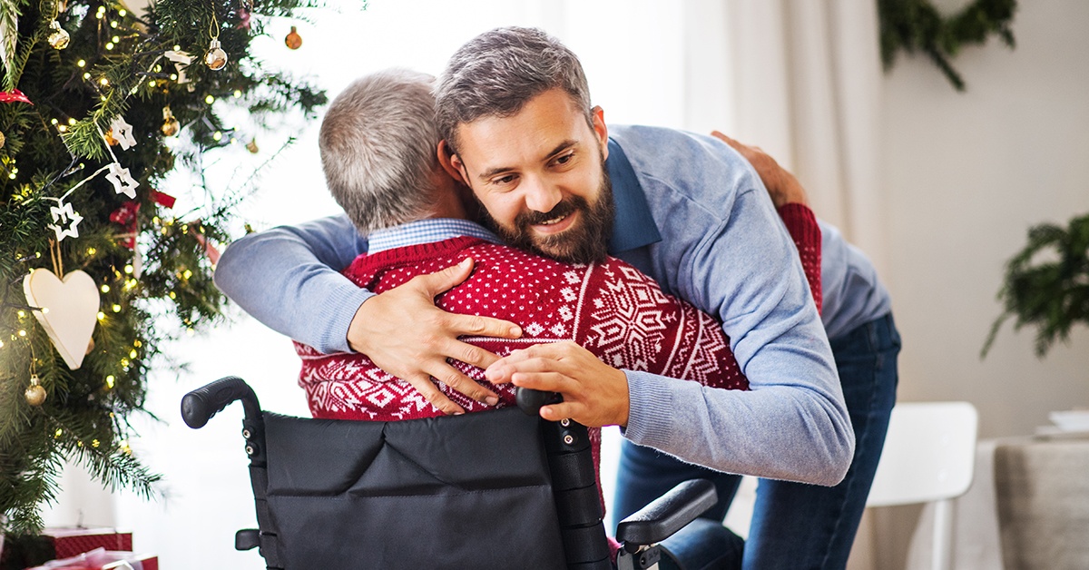 Man hugging father in wheelchair