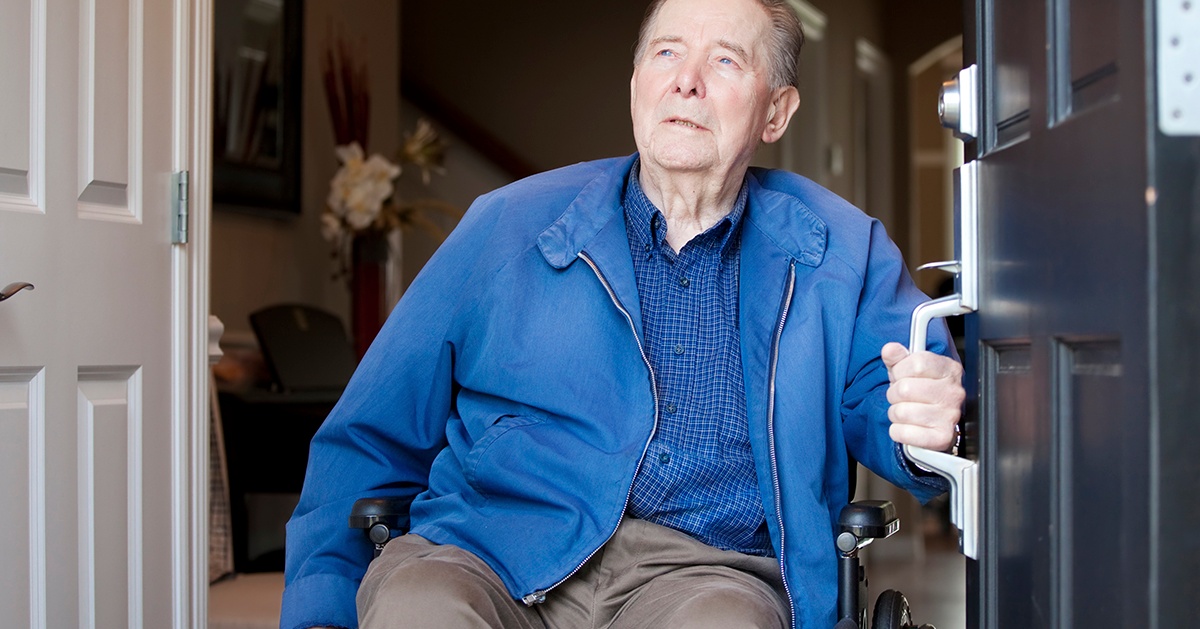 Man in wheelchair coming out of his home front door