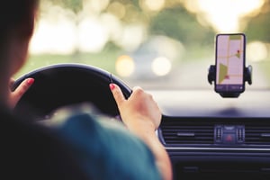 Woman driving and using smartphone's GPS