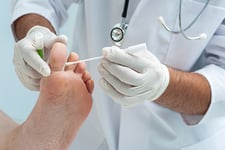 Podiatrist swabbing patient's foot