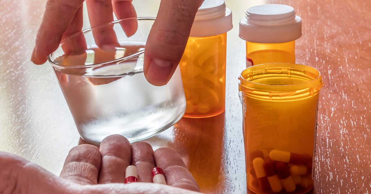 Person taking medication with water