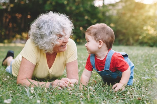 grandmother-old-senior-woman-lying-on-ground-grass-and-playing-with-her-little-baby-boy-grandson-on_t20_e9rJ47