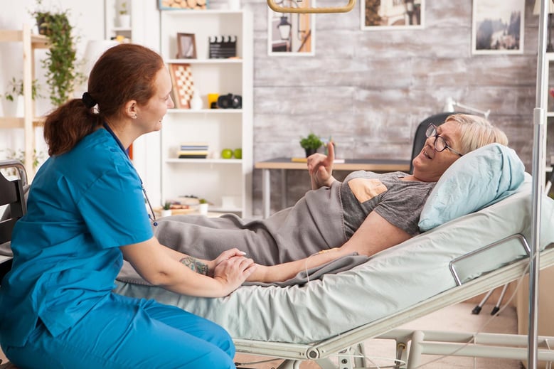 old-woman-laying-in-bed-in-a-nursing-home-talking-2023-11-27-05-09-37-utc