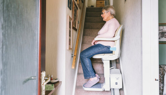 Senior woman using a stair lift at home